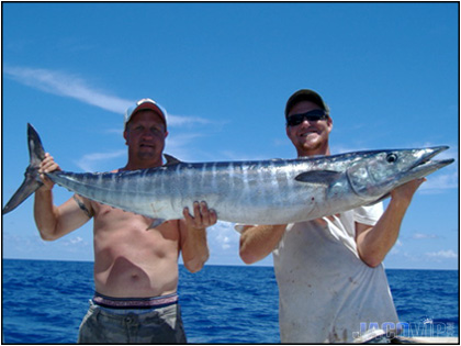 Two men smilling and holding large Wahoo Fish