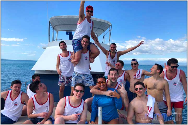 Group of guys with hands up having fun on party boat