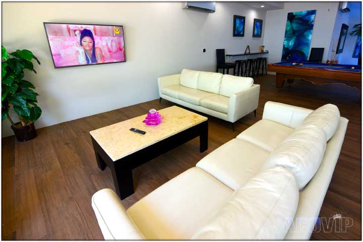 White sofas with Nicki Minaj video on the TV