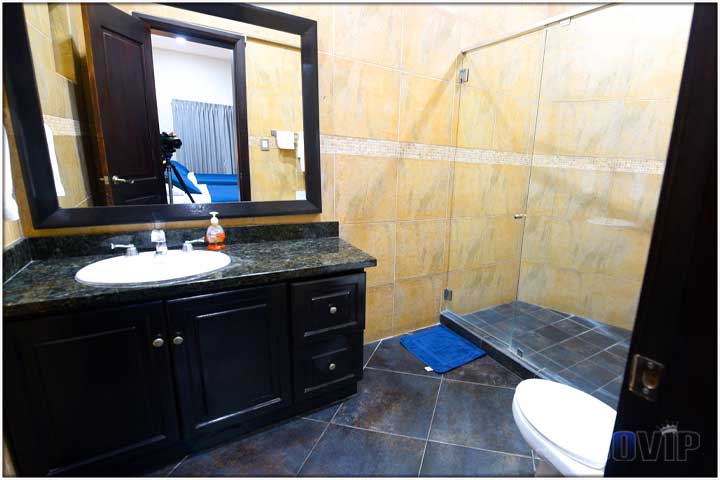 En suite bathroom with black granite and black tile on floor