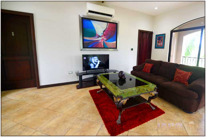 Lounge area with sofa and TV leading to bedrooms number 8 and 9