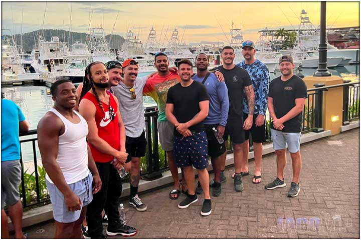 Group og guys at Los Sueños Village with boats in background