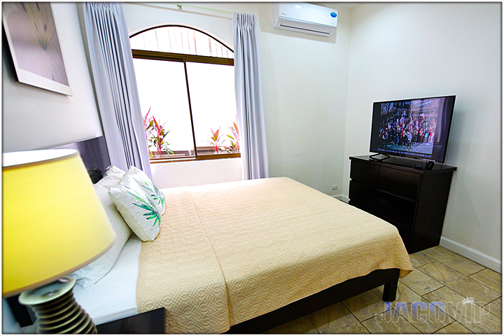 Corner view of bedroom with yellow lamp on nightstand