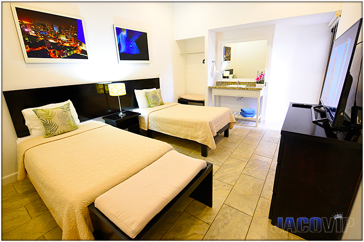 Bedroom with two single beds and sink in room