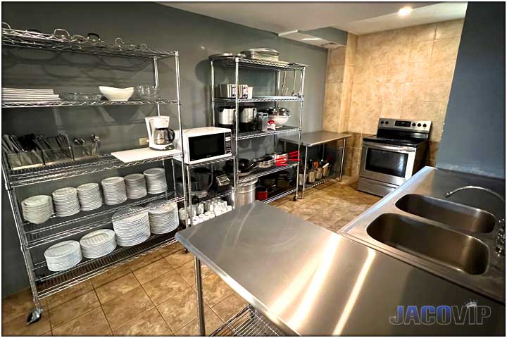 Large commercial style kitchen with stainless steel tables and shelves