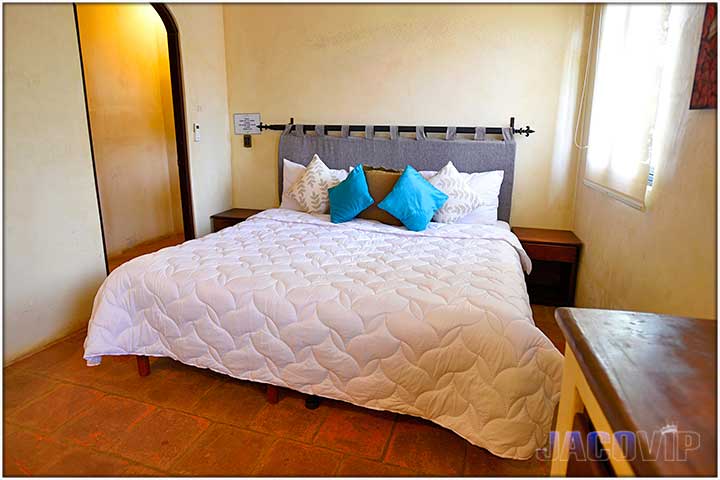 King size ed with white duvet cover and blue pillows