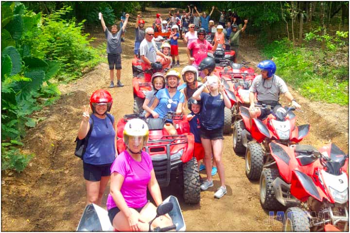 Large group stopped on dirt trail during ATV tour