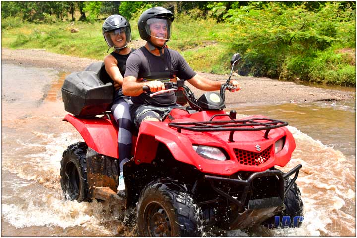 Couple crossing river on ATV