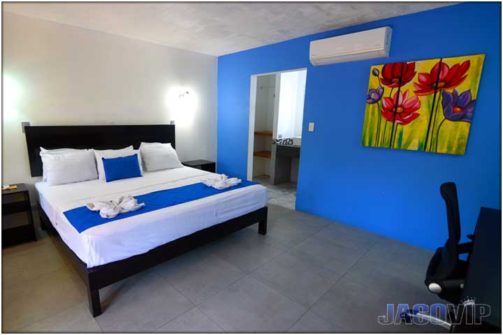 Blue wall in bedroom with painting of flowers