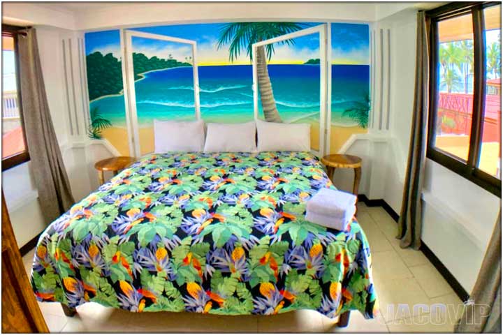 Floral bedspread and ocean view painting on wall