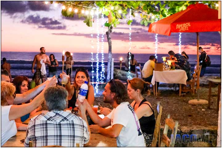 People eating at drinking at sunset