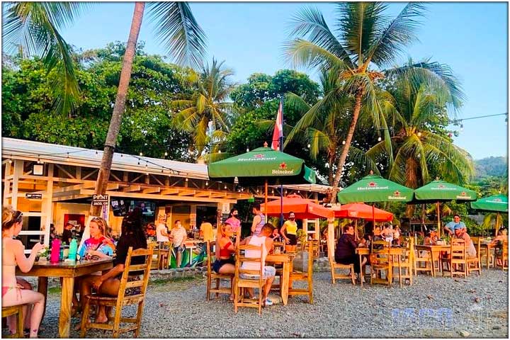 View of El Point with people sitting at tables from Jaco Beach