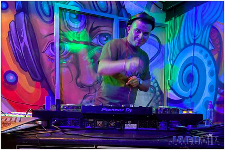 Dj with colorful wall behind him