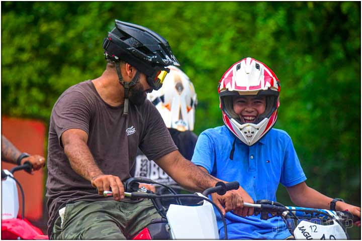 Guide with young rider on mini dirt bike