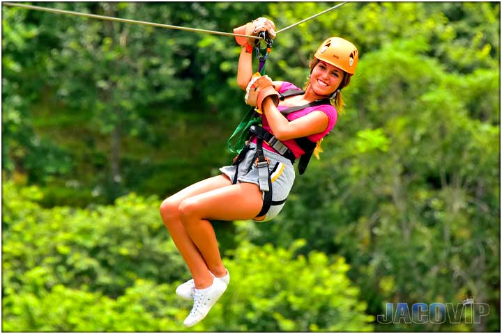 Pretty girl on zip line tour with hand on cable