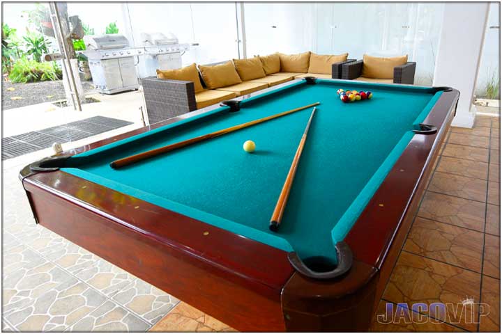 Corner angle view of pool table and sofa seating in living room