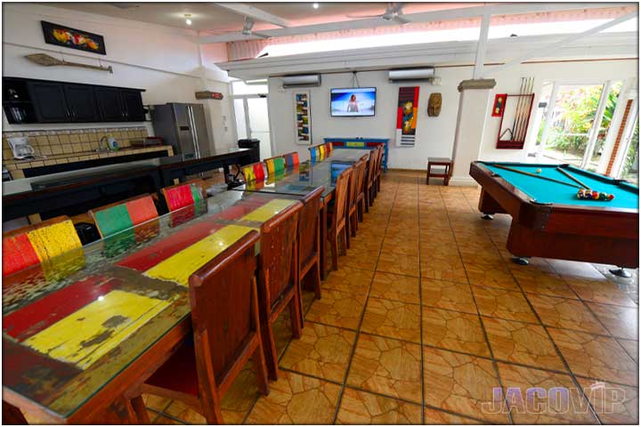 Long view of dining tables and pool table in living room