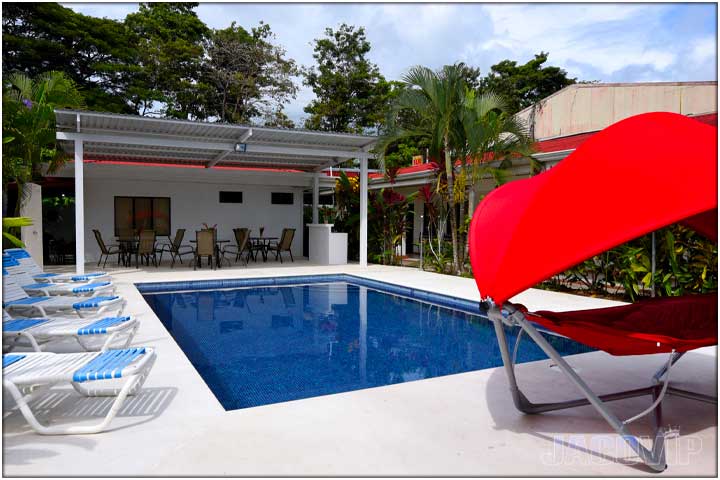 Corner view of swimming pool and red swing chair