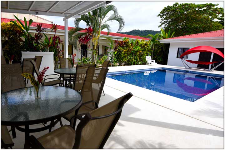 Corner view of table and chairs next to pool