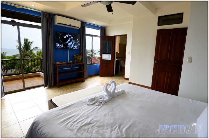 King size bed with large TV and sunset views of Pacific Ocean