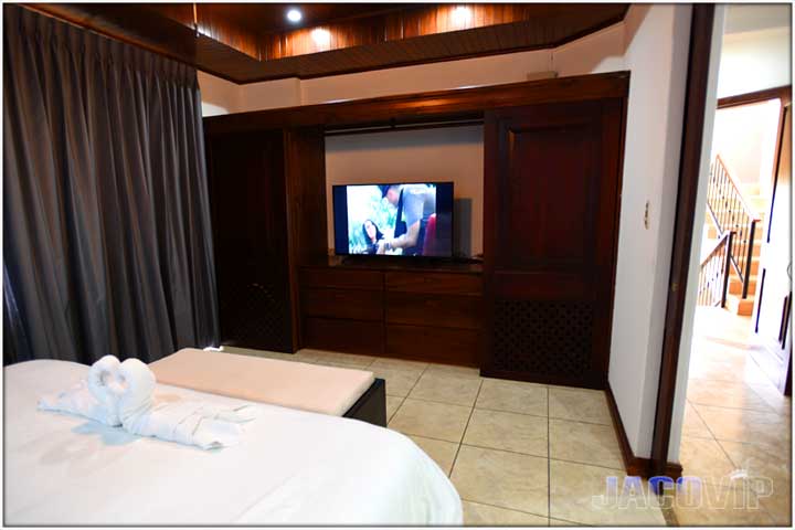 King size bed with TV and looking out door to staircase
