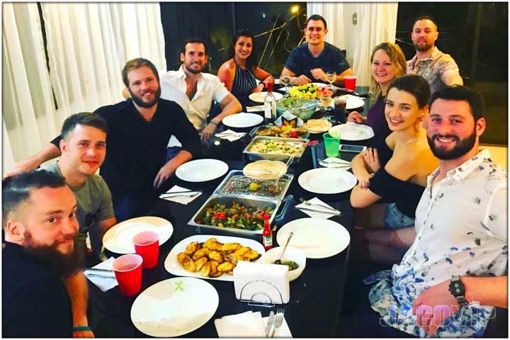 Mixed group at dining table about to eat dinner