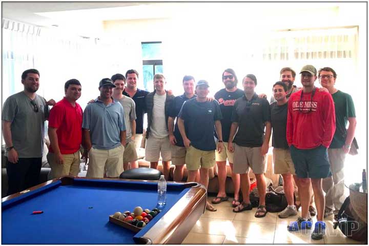 Large bachelor party group in front of pool table and sun shining in