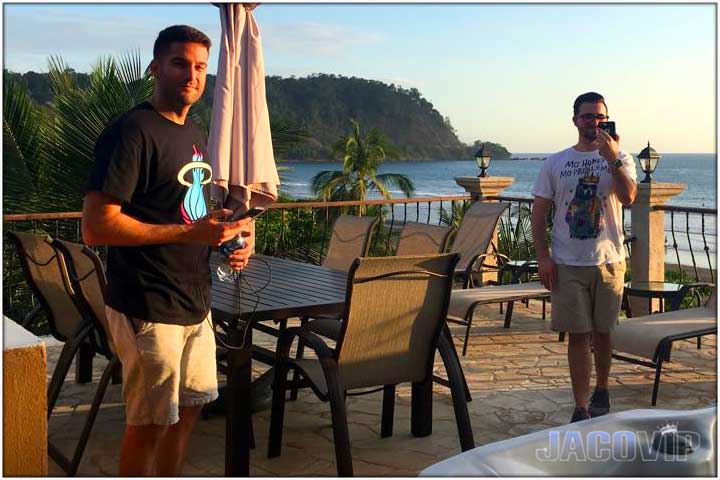 Two guys on cell phone at sunset time in Jaco