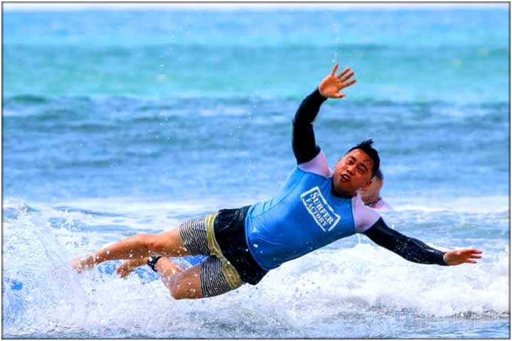 Guy diving off surfboard