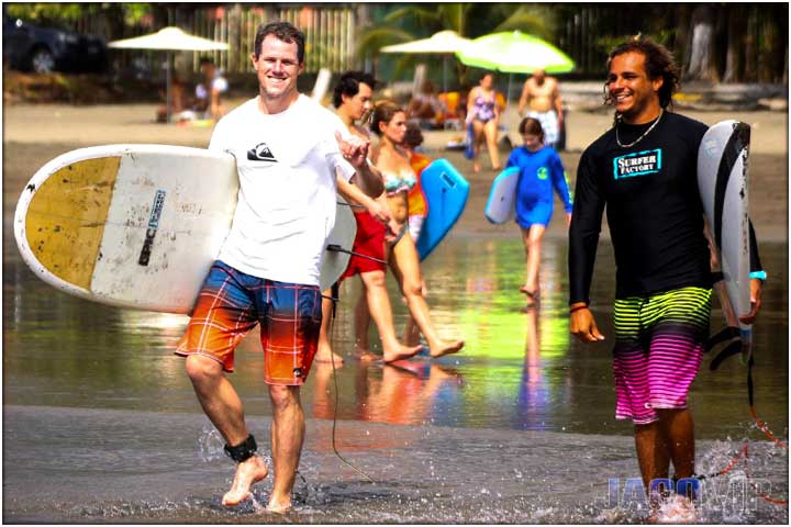 Surf instructor and student walking into the ocean in Costa Rica