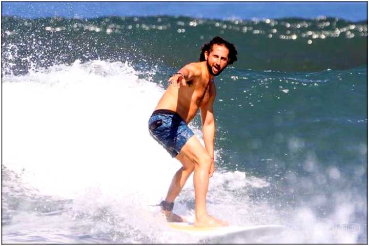 Guy standing up on surfboard for first time