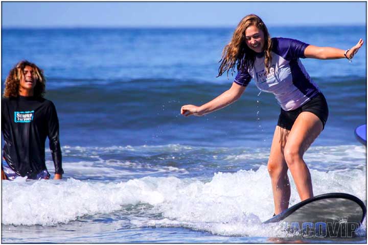 Instructor helping surf lesson student in the ocean