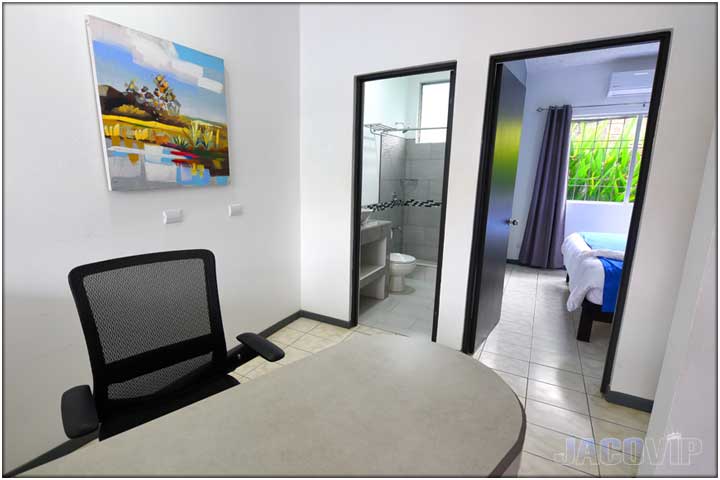 Close up of desk and office chair with bathroom door behind