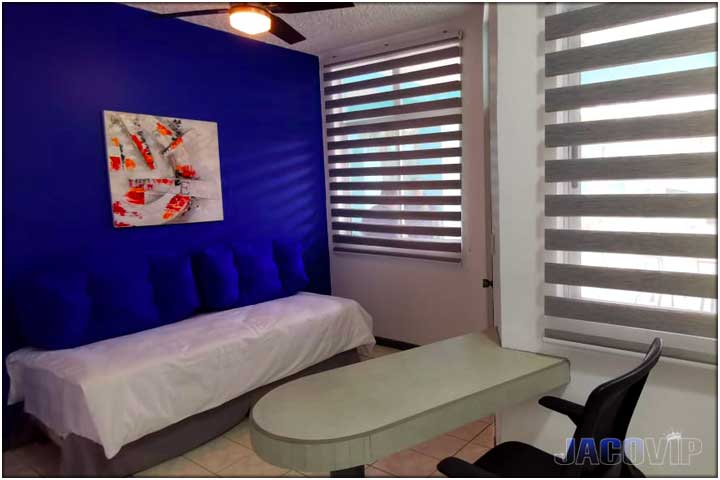 Day bed with blue pillows and blue wall