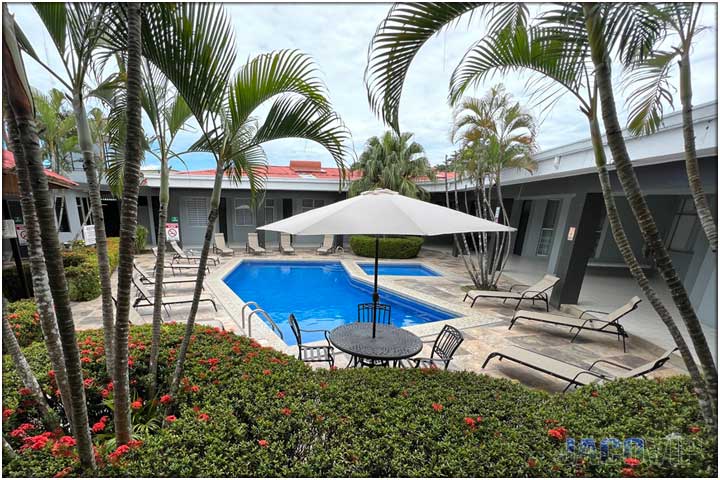 Back of lounge chairs with view of pool and both buildings