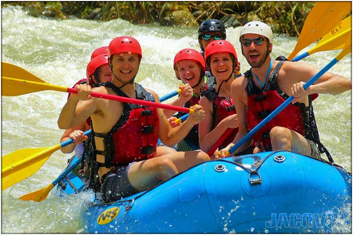 Guys on blue river raft with red life jackets and yellow paddle oars