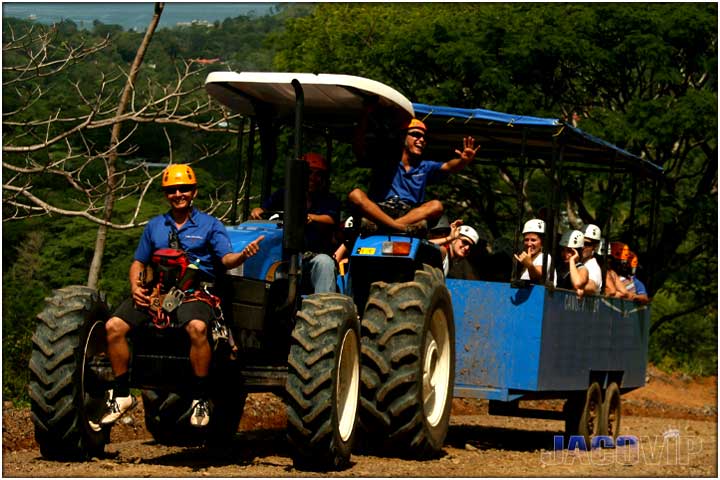Close up of blue tractor with zipline tour guides and guests