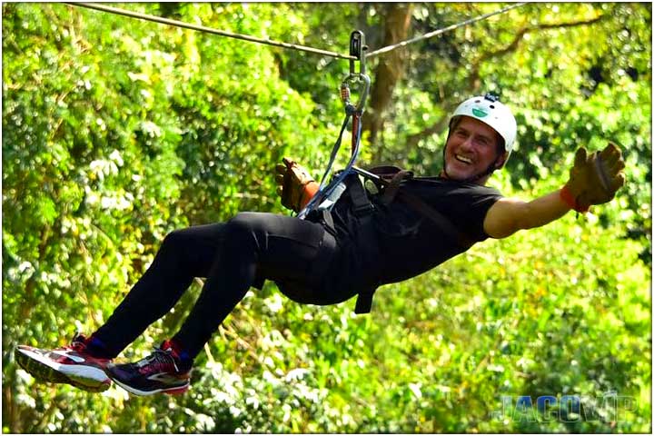 Guy with black pants and white helmet on zipline tour